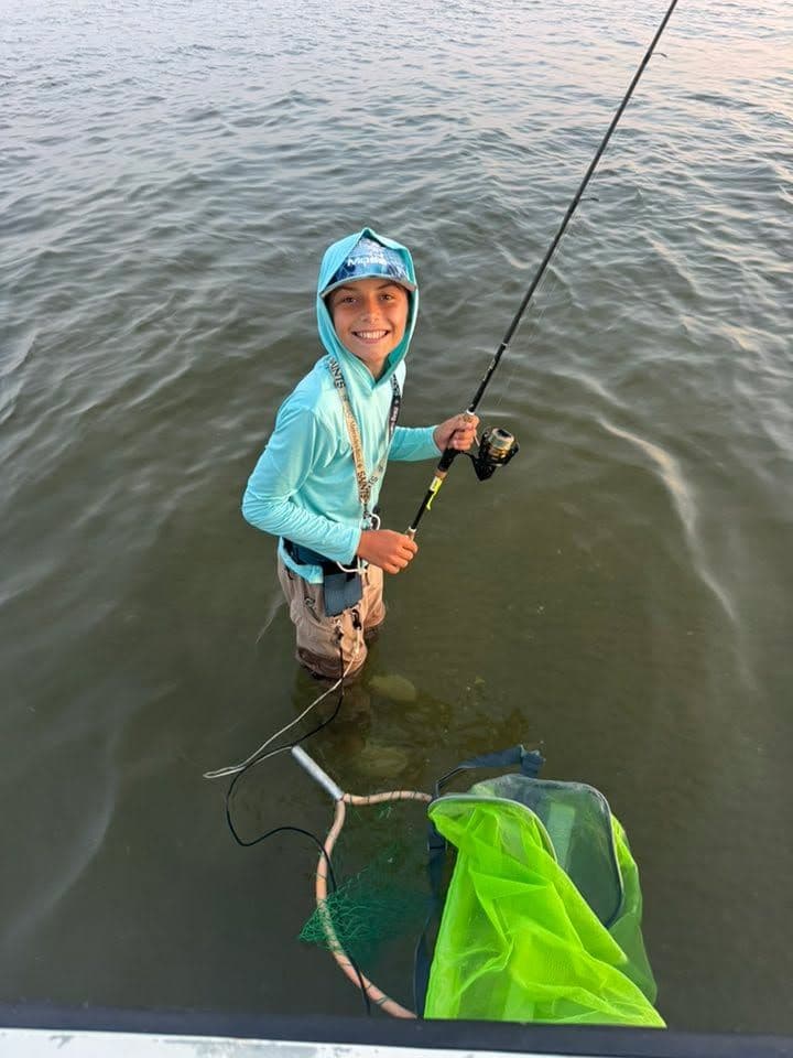 A happy young angler enjoying a day of fishing in the shallow waters of Louisiana. Ready for the next big catch!
