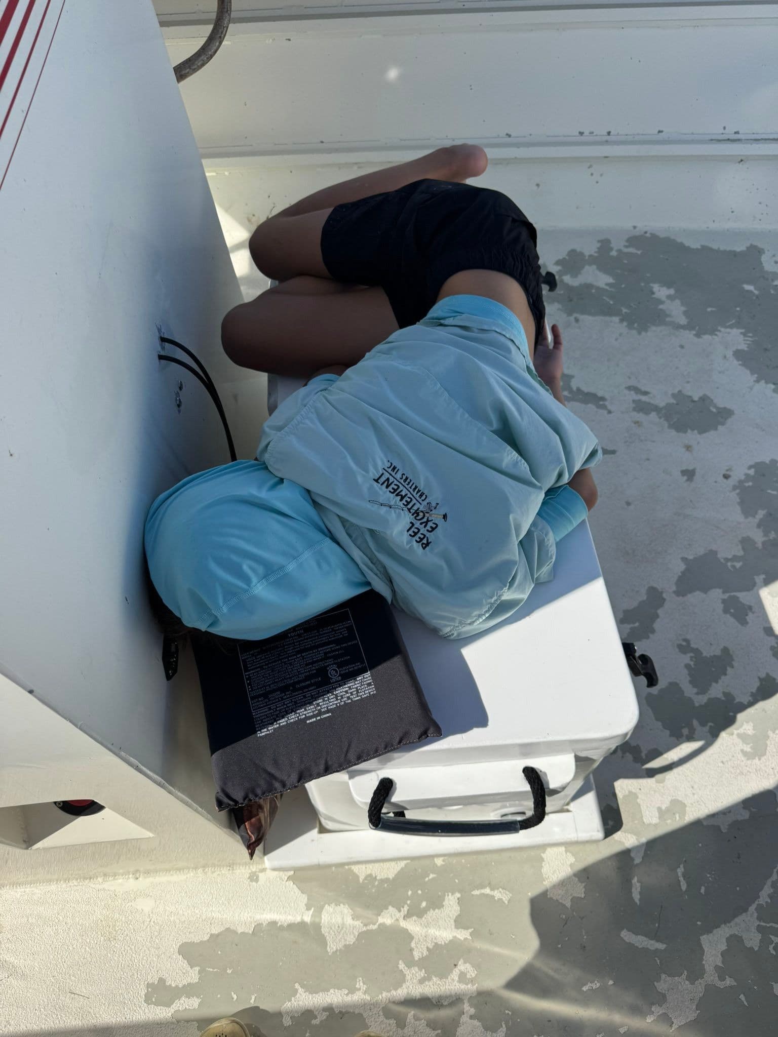 Even the most exciting fishing trips can lead to some well-deserved rest! This angler is taking a break on the deck, recharging for more action with Reel Excitement Charters.